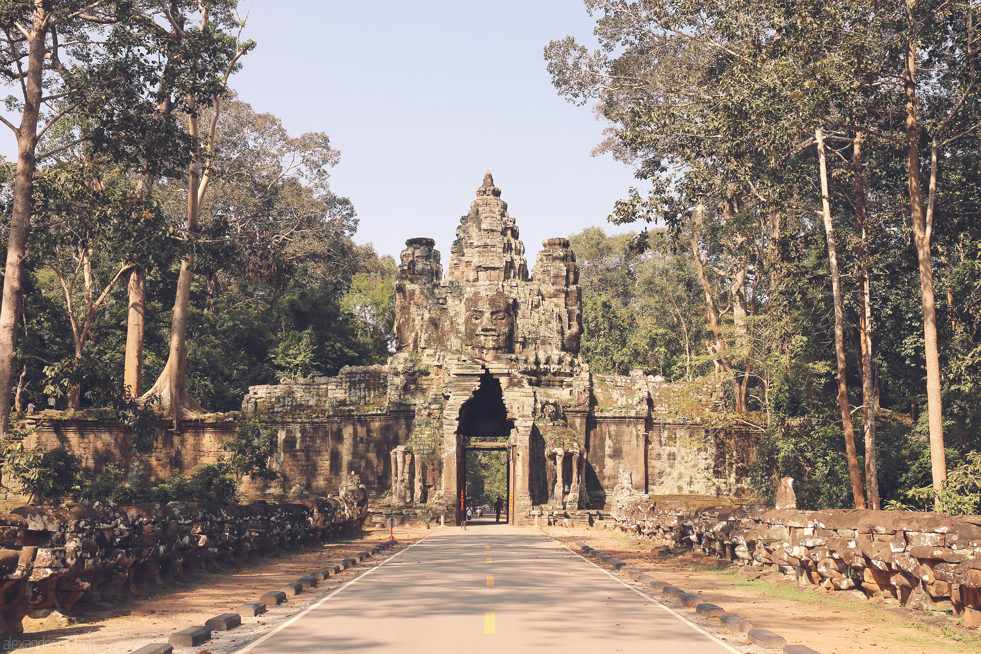 Foto von Ancient stone faces greet you at the iconic gate of Angkor Thom, nestled in the lush forests of Siem Reap, Cambodia.