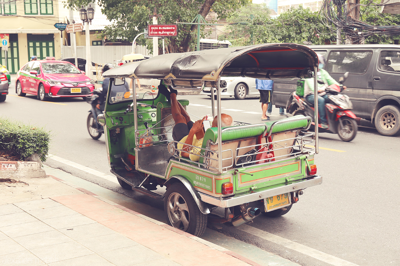 Foto von A vibrant tuk-tuk waits on a bustling Bangkok street, echoing the city's lively pulse and colorful culture.