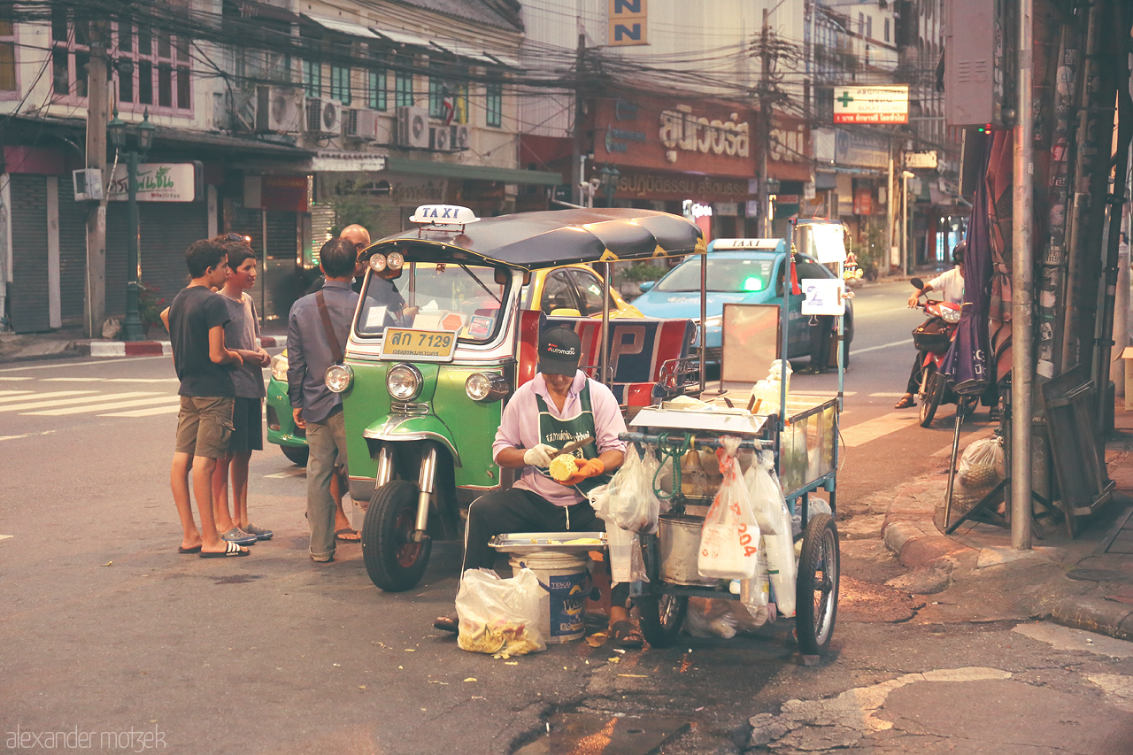 Foto von Evening falls on Talat Yot, Bangkok, where the bustling street life and a colorful tuk-tuk reflect the city's vibrant charm.