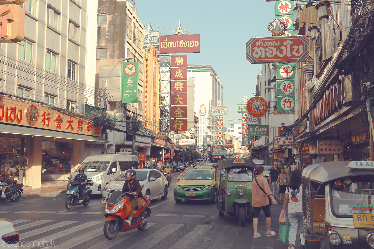 Foto von Vibrant streets of Chakkrawat, Bangkok buzz with scooters and tuk-tuks amidst colorful signs, capturing the heart of Thai city life.