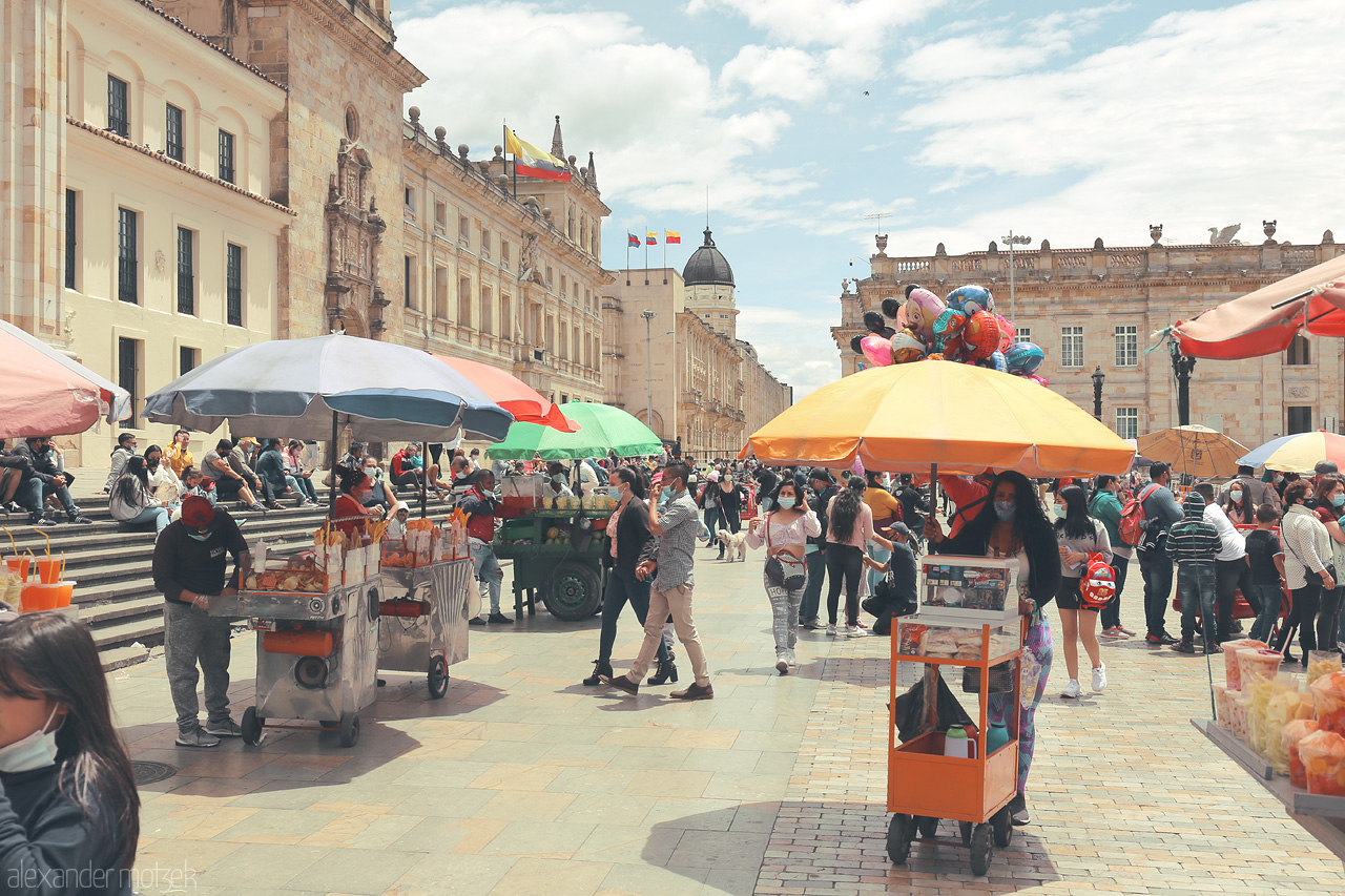 Foto von A bustling street scene in La Candelaria, Bogotá with vibrant umbrellas, vendors, and an atmosphere of local culture and joy.