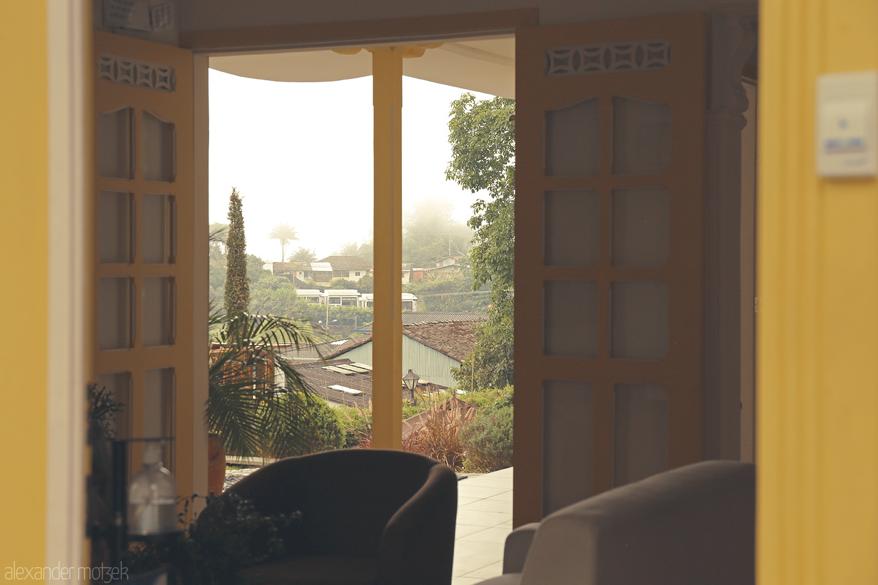 Foto von A serene view through an open door in Salento, Quindío, Colombia, capturing the misty landscape and vibrant greenery typical of the region.