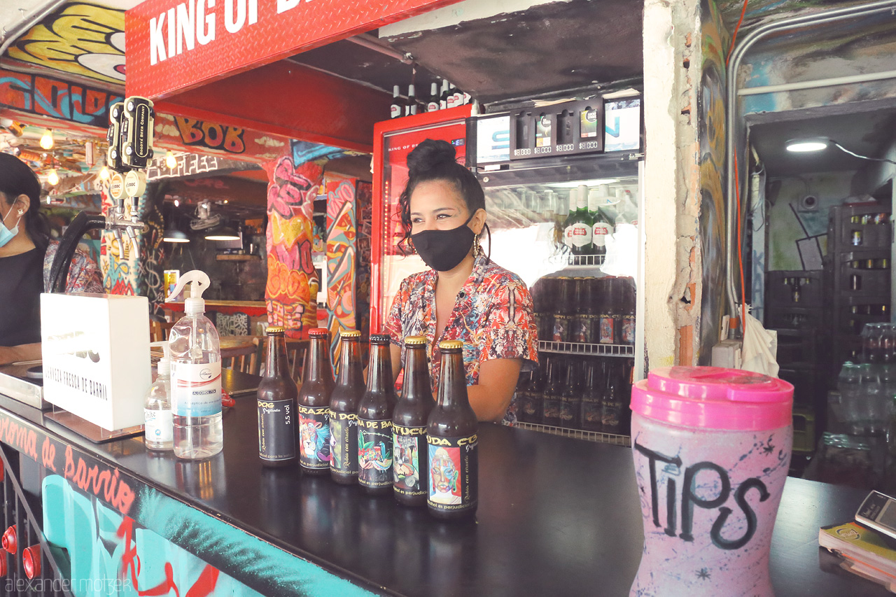 Foto von A vibrant moment in Comuna 13, Medellín where friendly locals serve drinks amidst colorful street art and graffiti. A hub of urban culture and inspiration.