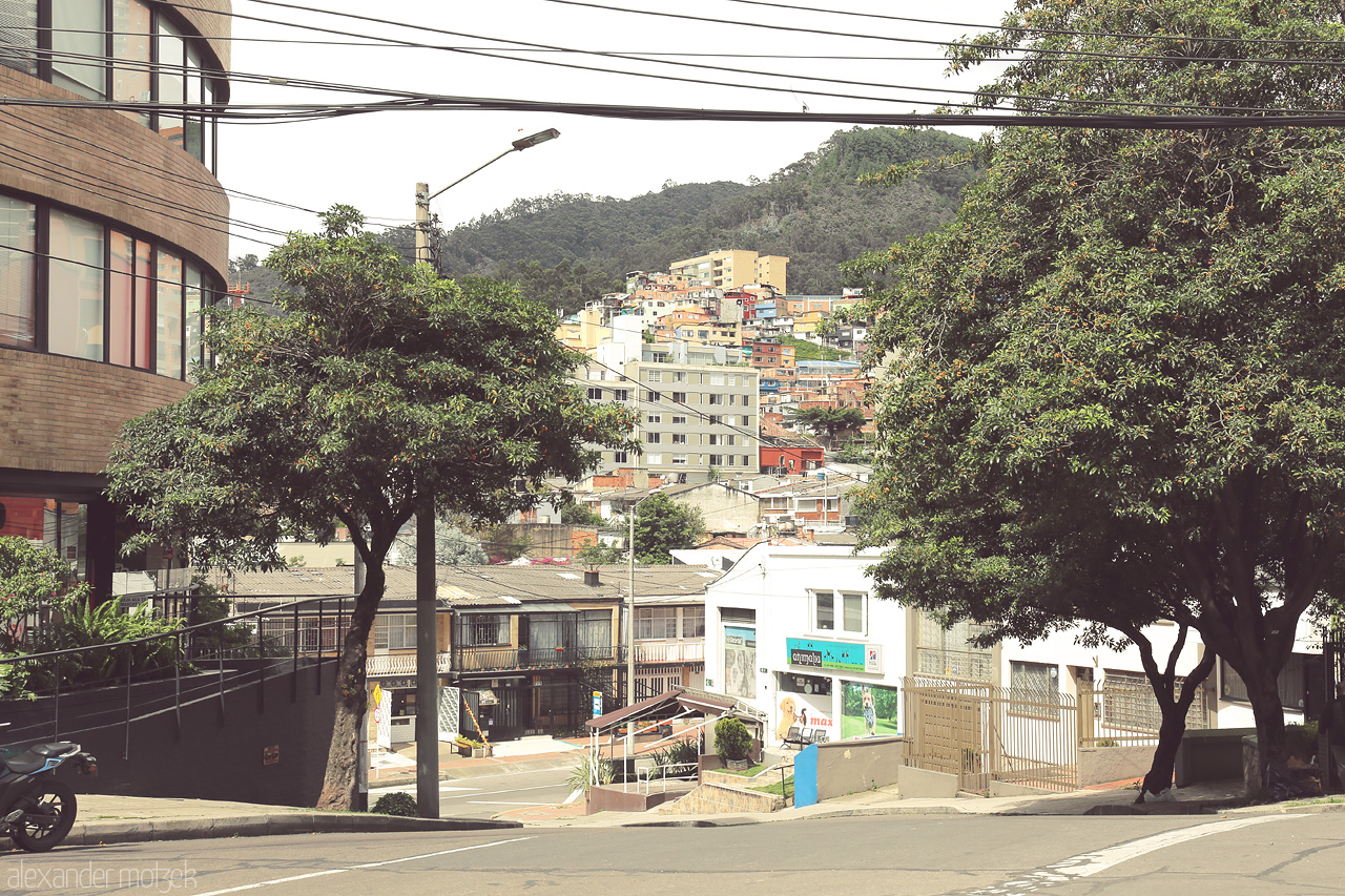 Foto von A vibrant street scene in Chapinero, Bogota, where urban life meets lush greenery against a hilly backdrop.