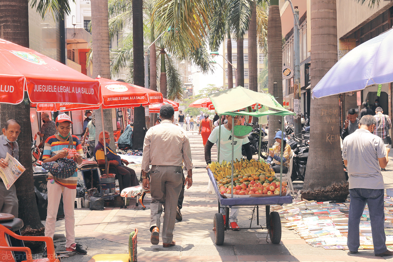 Foto von Bustling street life in Comuna 3, Cali, Colombia. Vibrant vendors selling fruits and wares under colorful parasols.