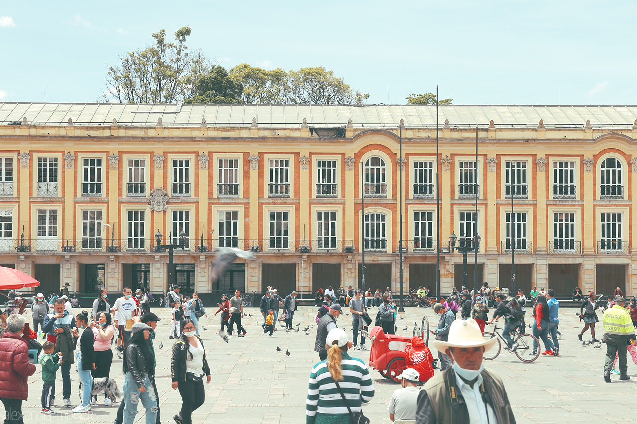 Foto von Lively scene in La Candelaria, Bogota, Colombia: people, pigeons, and colonial architecture under a bright, serene sky.