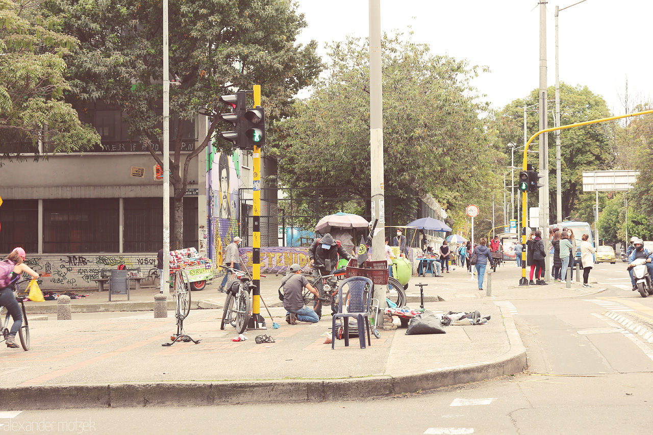 Foto von Locals repair bikes on the streets of Chapinero, Bogota, Colombia, capturing the essence of community and urban life.