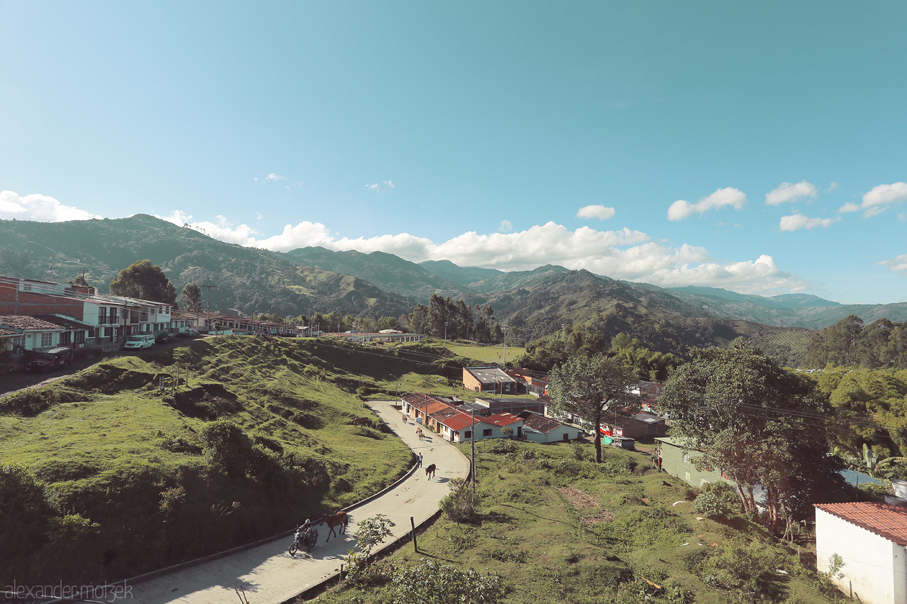 Foto von Morning light bathes Salento, Quindío in serene warmth. Teal skies and lush mountains frame a peaceful village nestled in Colombia's Andean heart.