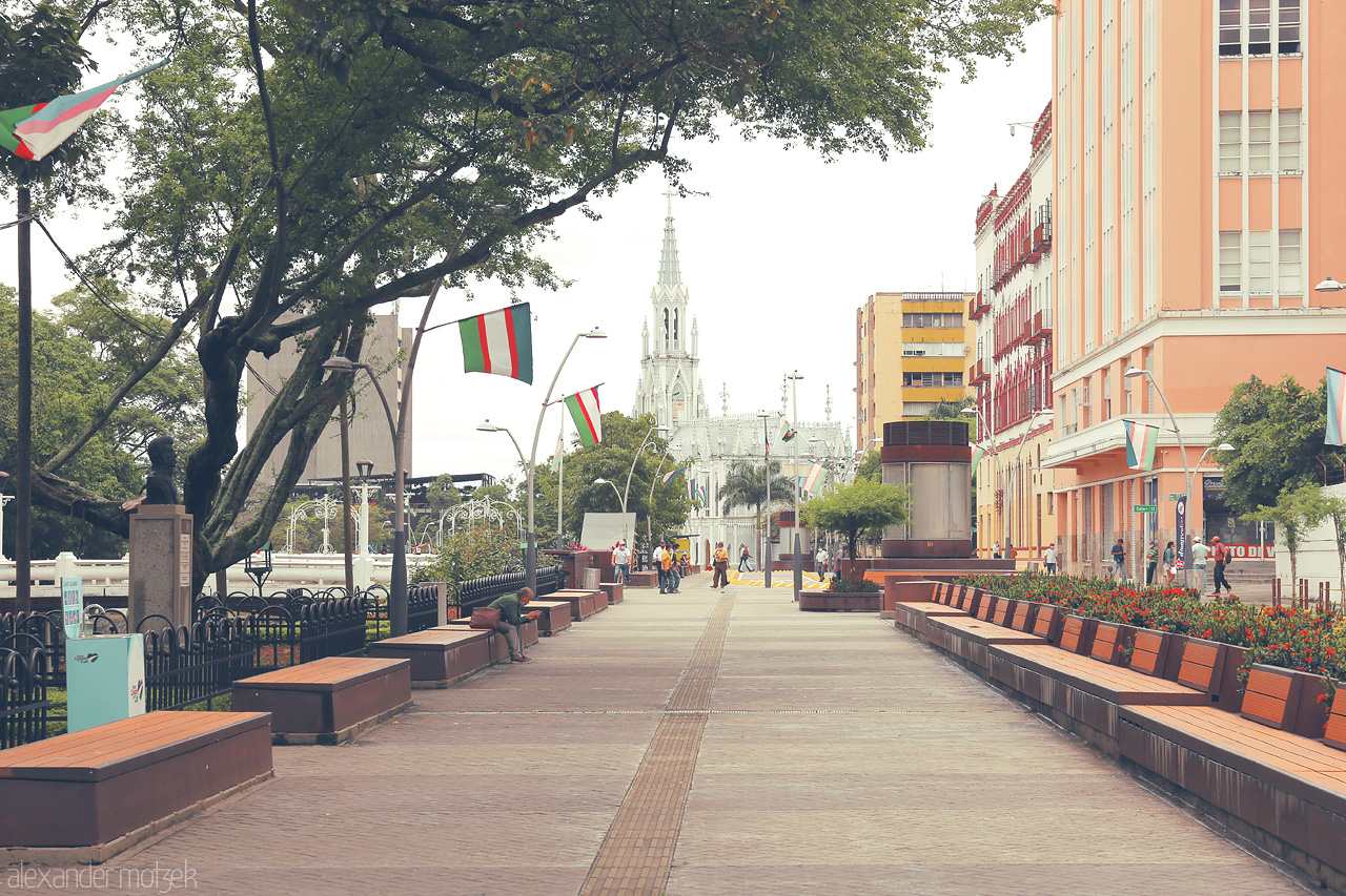 Foto von Strolling through Comuna 3 in Cali, Colombia, with lush greenery, vibrant flags, and historic architecture capturing the spirit of the city.