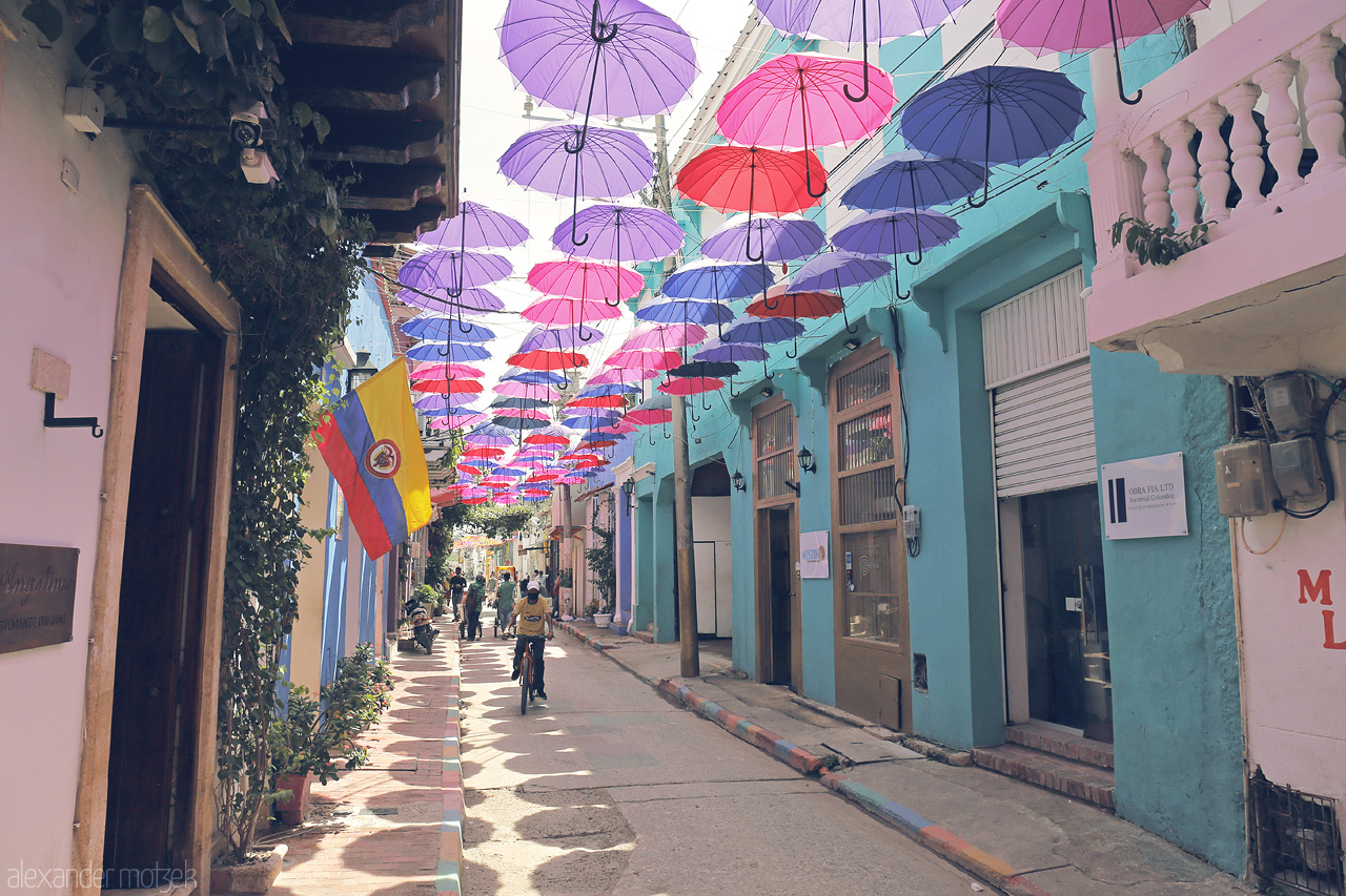 Foto von Vibrant umbrellas create a canopy on a street in Cartagena, Colombia, casting colorful shadows and adding charm to a picturesque passage.