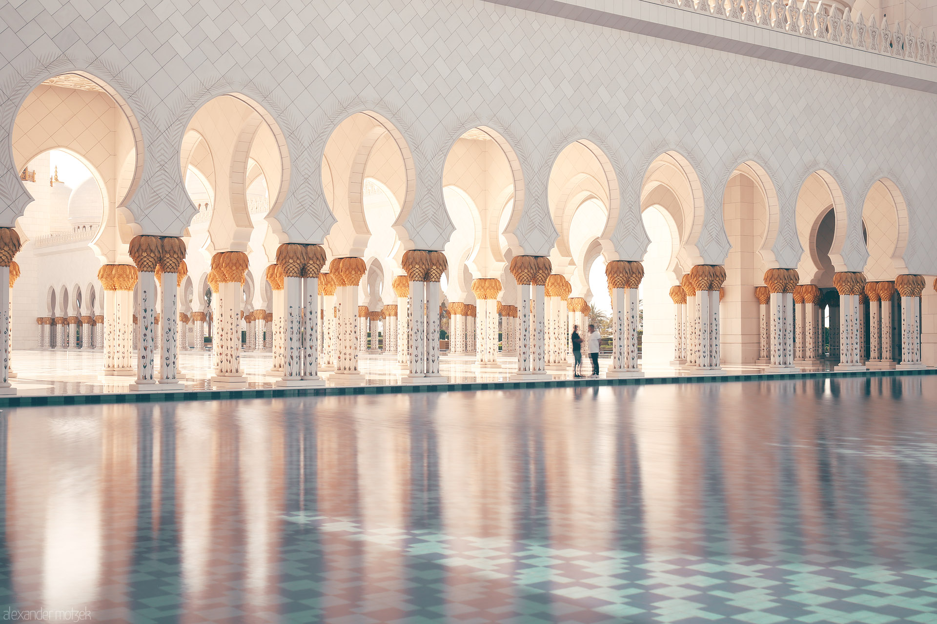 Noor Reflections Foto von Golden columns and arched walkways shimmer on tranquil waters at Sheikh Zayed Grand Mosque in Al Rawdah, Abu Dhabi, UAE.