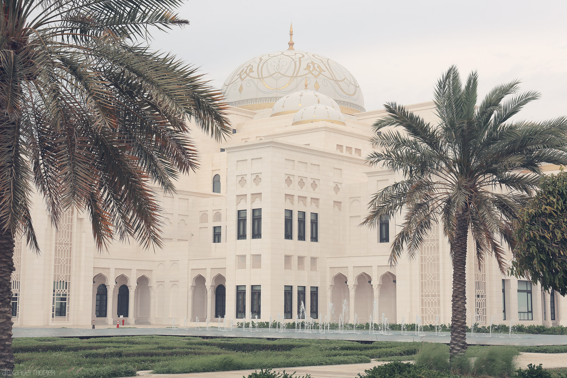 Qasr Serenity Foto von Majestic white domes and arches rise behind palms in Al Ras Al Akhdar, Abu Dhabi; modern elegance meets timeless Arabian grace.