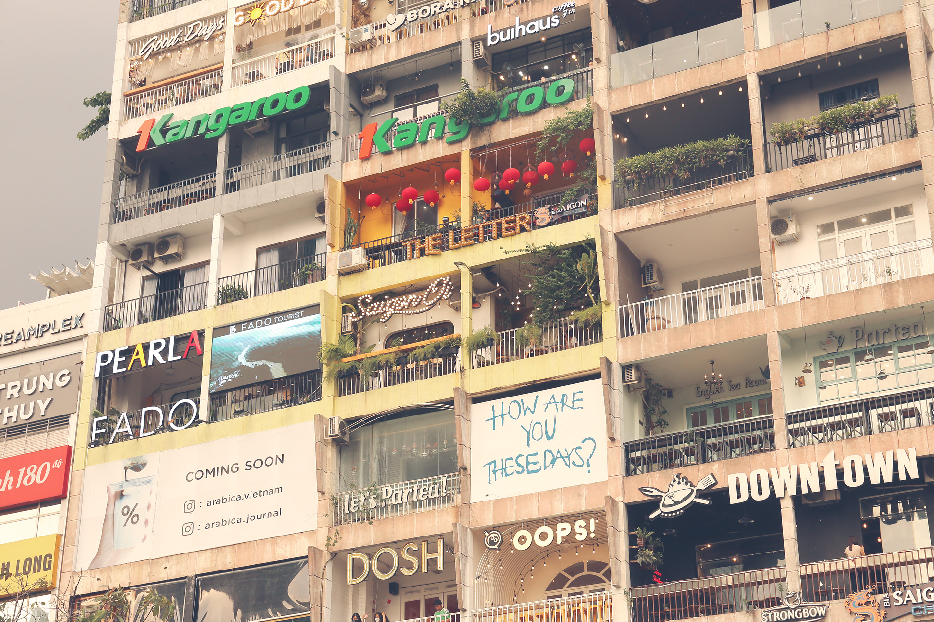 Foto von Eclectic cafes, neon signs & life on the iconic Saigon apartment block in downtown Ho Chi Minh City.