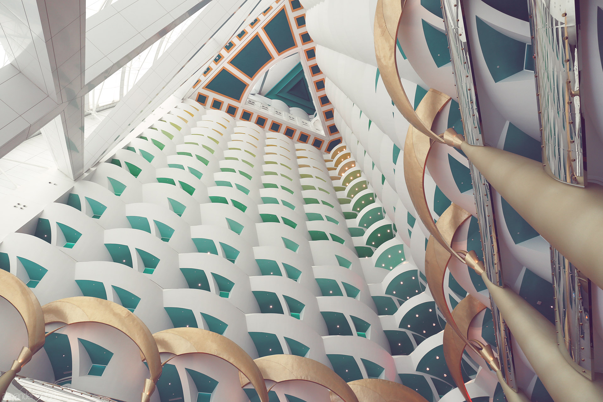 Foto von Inside Dubai’s Burj Al Arab: soaring geometric patterns, golden arches, and turquoise hues capture the city’s opulent modernity.