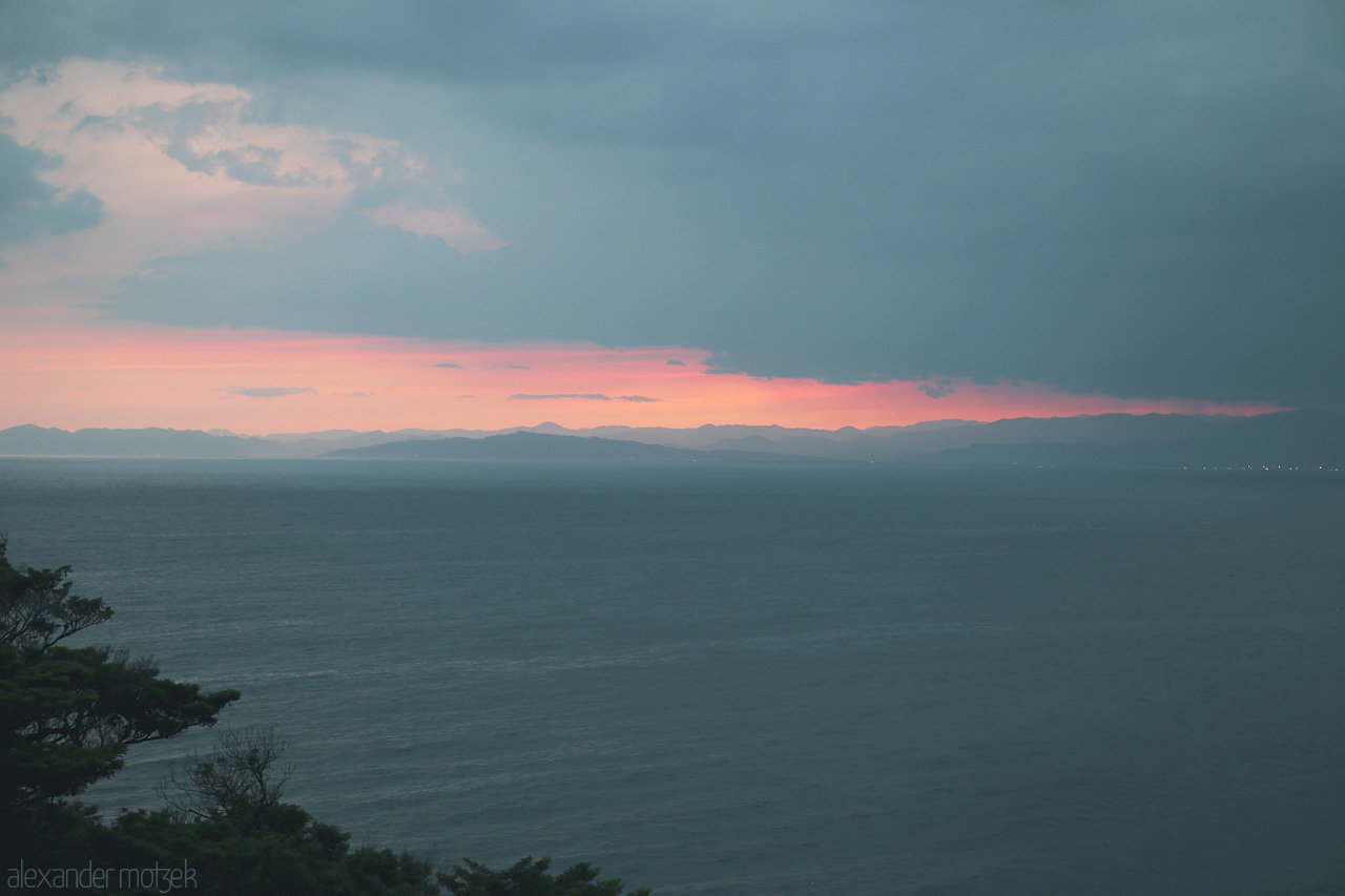 Foto von A captivating sunset over the Izu coastline in Shizuoka, Japan, with soft hues blending sea and sky.