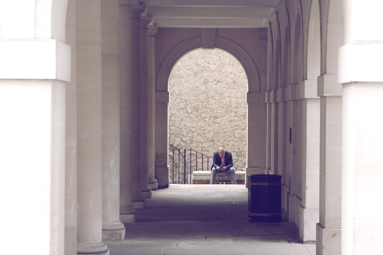 Foto von A solitary figure reflects in a stone archway in London, revealing the serene beauty of urban solitude.