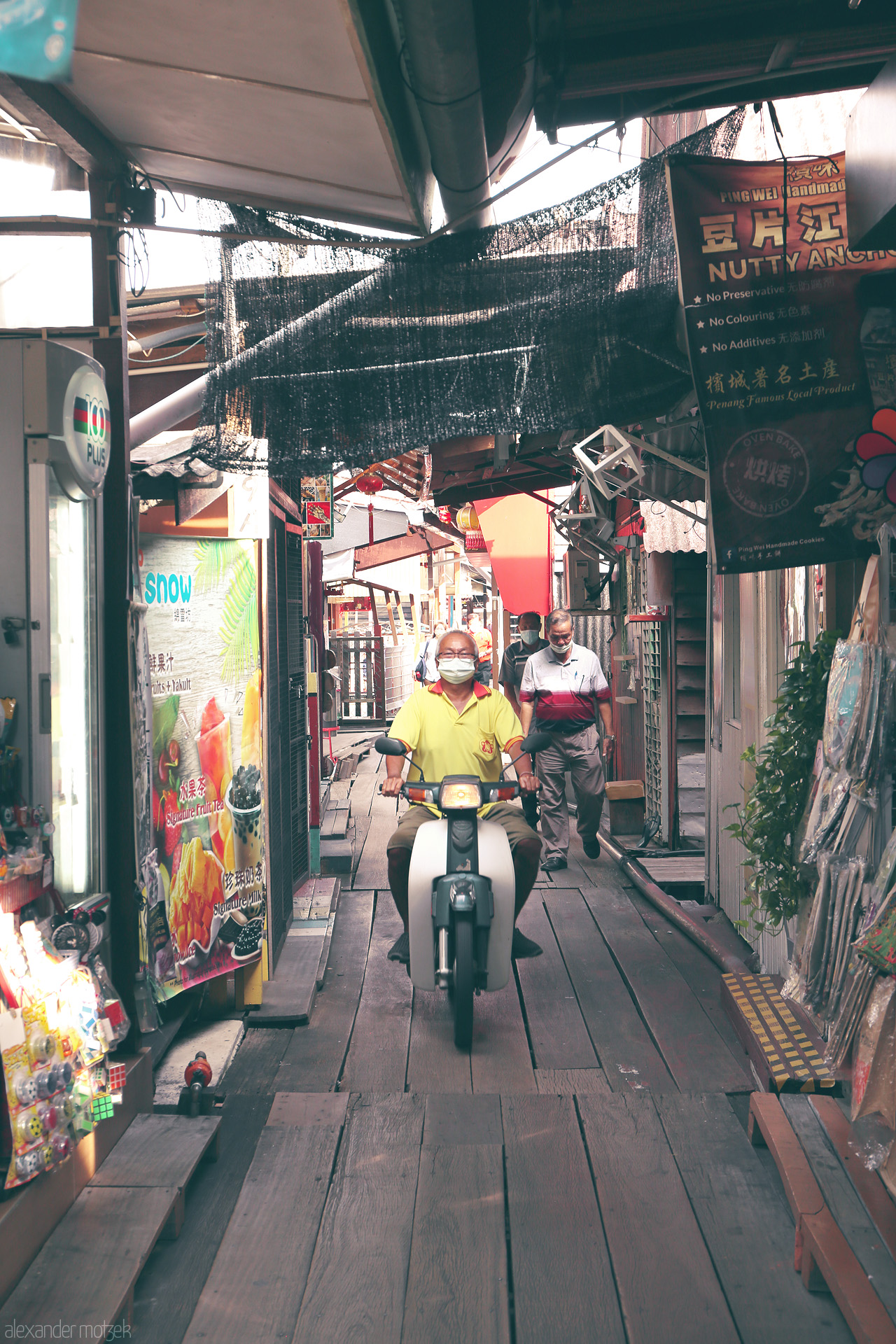 Foto von A bustling alley in Penang features locals navigating daily life, capturing the vibrant street culture and unique charm of Malaysia.