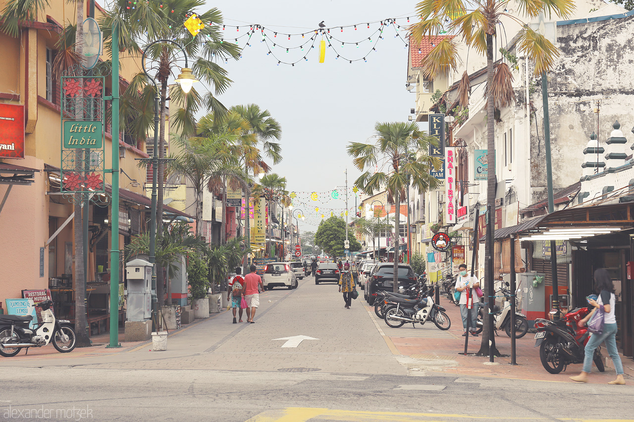 Foto von Bustling George Town in Penang, Malaysia, brims with vibrant shops and palm-lined streets echoing colonial charm and cultural fusion.