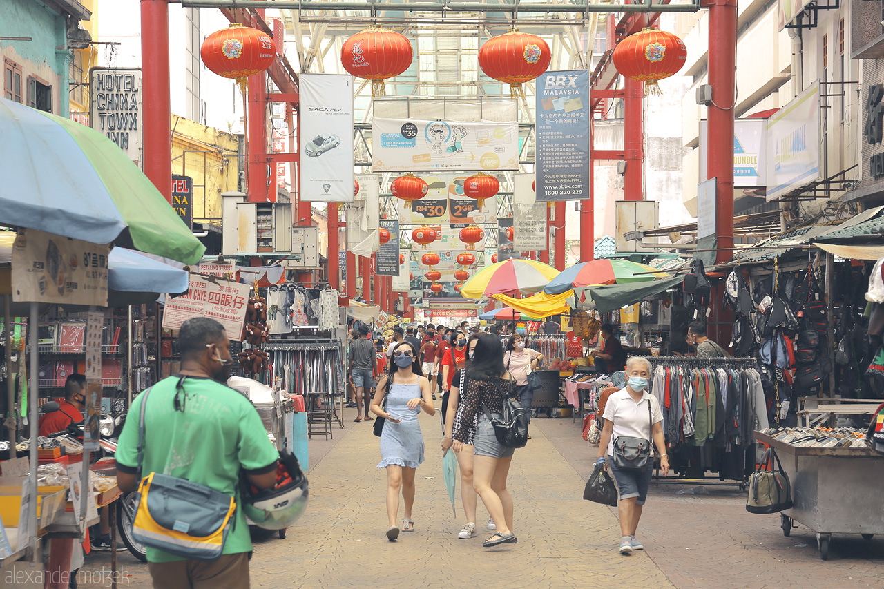 Foto von Bustling Petaling Street in Kuala Lumpur, adorned with vibrant red lanterns and colorful stalls offering local goods.