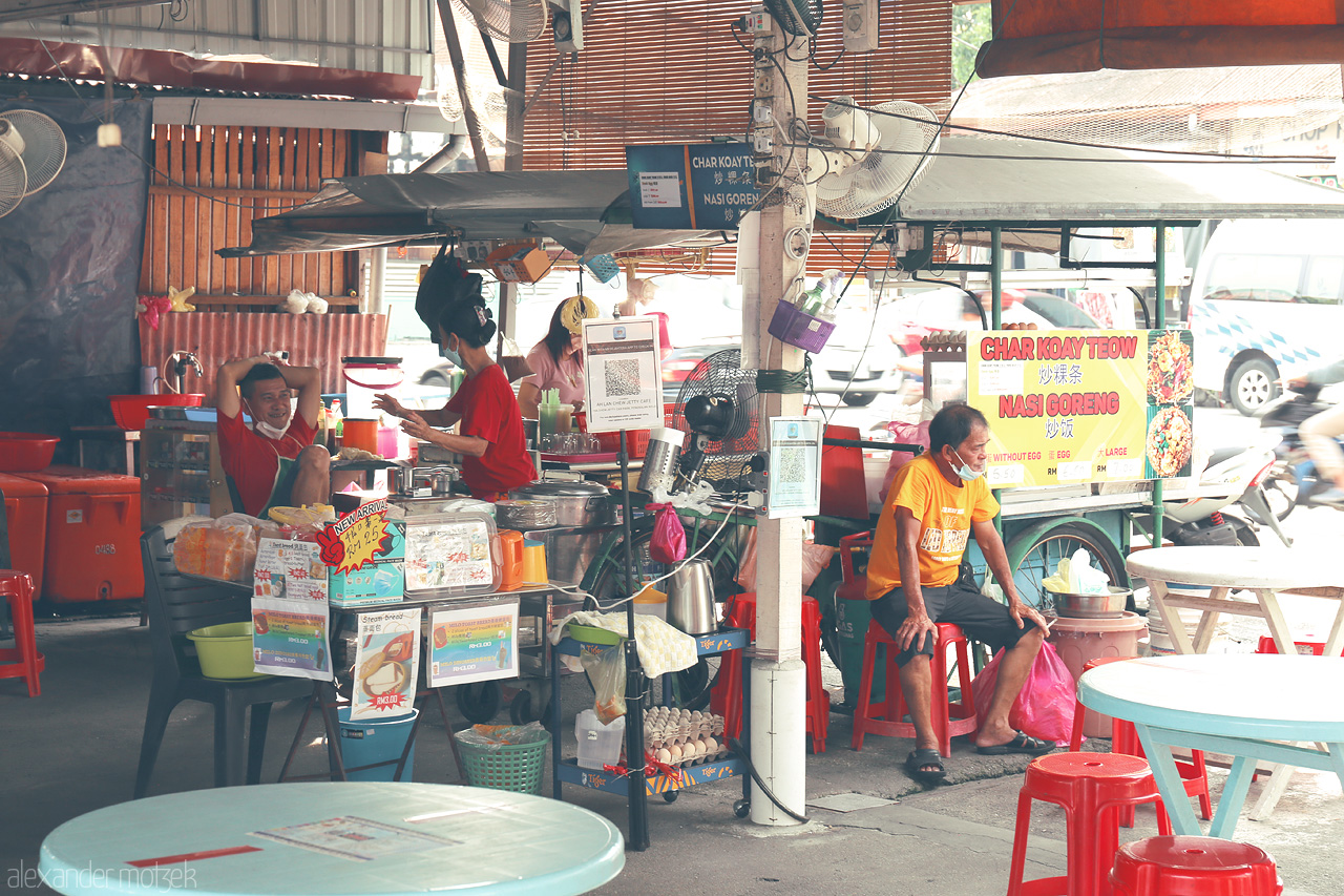 Foto von Experience the vibrant charm of Penang's street food culture with a bustling Char Koay Teow stall and colorful local life.