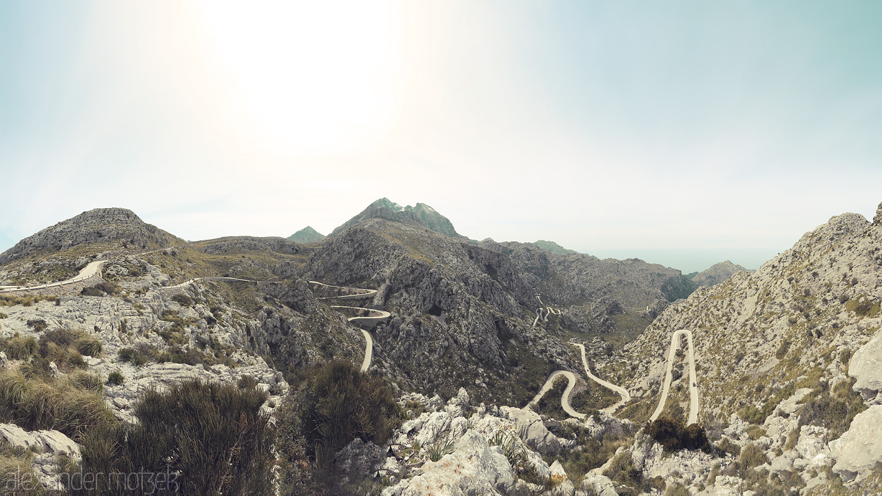 Foto von Panoramic view of winding roads through the Serra de Tramuntana in Escorca, Mallorca, under a soft sunlit sky.