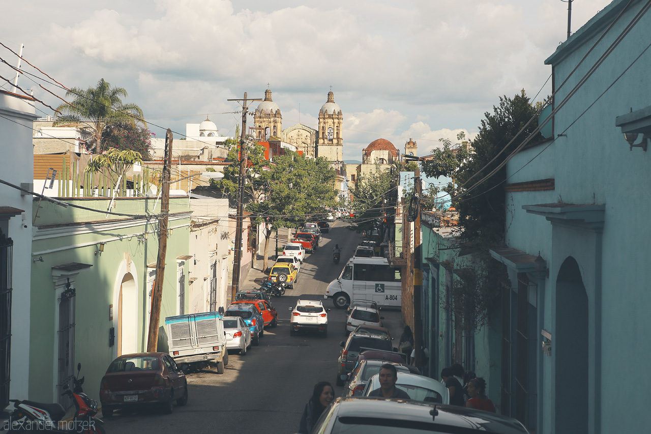 Foto von A bustling street in Oaxaca de Juárez framed by traditional architecture under the Mexican sun.