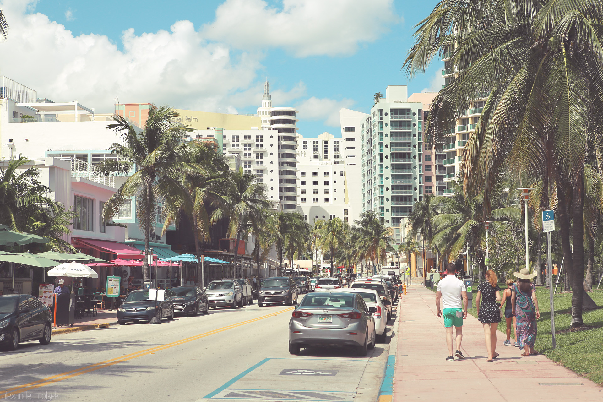 Foto von A lively street scene in Miami's Art Deco District, framed by pastel buildings, swaying palms, and a sky that kisses the Atlantic breeze.