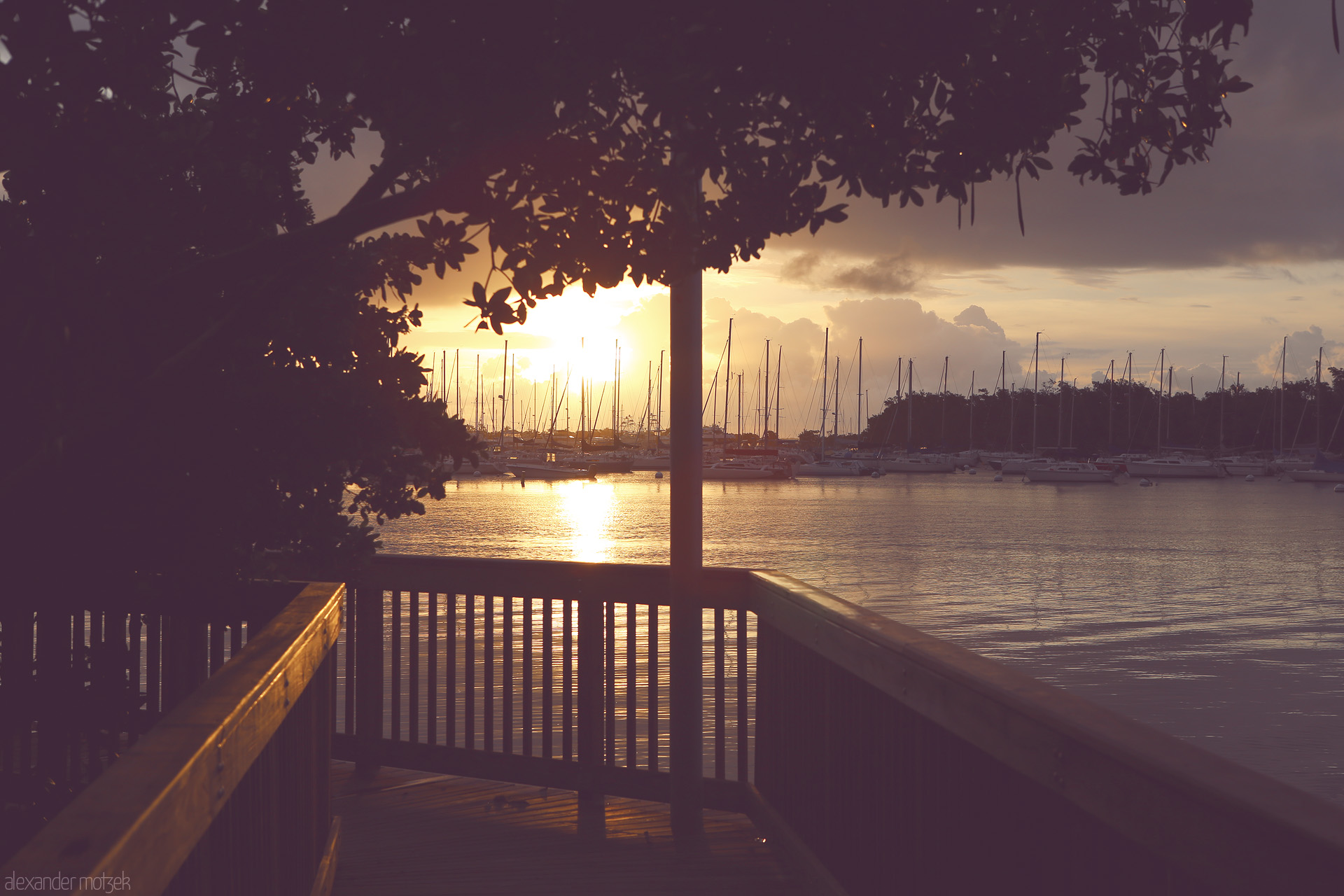 Foto von A tranquil sunset over Miami's marina, where sailboats rest under a golden sky, capturing the essence of tropical serenity.