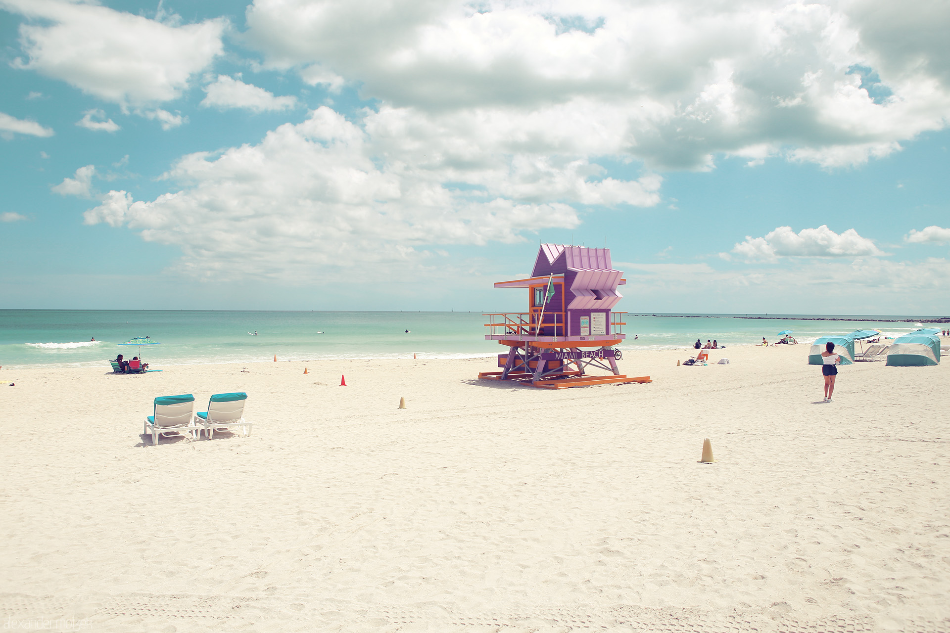 Foto von A vibrant lifeguard tower stands on Miami Beach, Florida under a sunlit sky, inviting tranquil seaside moments.