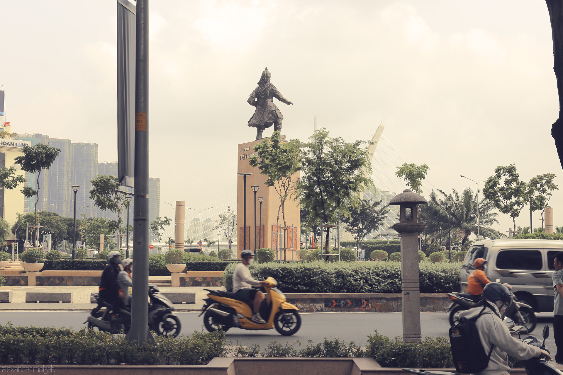 Foto von Scooters whirl past the Tran Hung Dao statue in lively Ho Chi Minh City, Vietnam—a vibrant cityscape in perpetual motion.