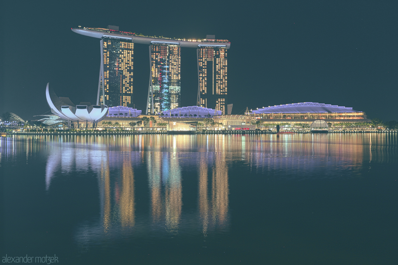 Foto von A mesmerising night view of Marina Bay Sands and surrounding architecture in Singapore, beautifully mirrored in the calm waters.