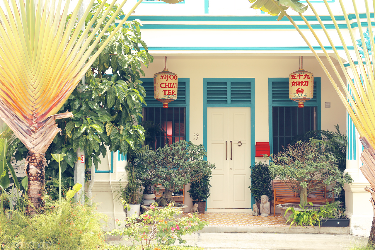 Foto von Bright Peranakan shophouse at No. 59 in Singapore with vibrant plants, traditional Chinese lanterns, and unique architecture.