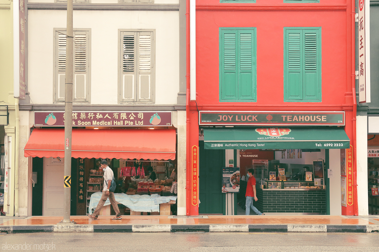 Foto von Exploring Singapore's Kampong Glam: a colorful shophouse street with a mix of medical shops and a cozy tea house. A journey of vibrant culture.