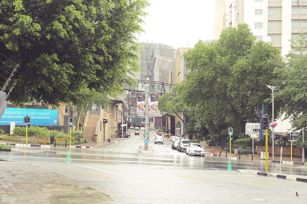 Foto von A rainy day in Sandton, Johannesburg's bustling heart, where modern architecture meets lush greenery and vibrant city life.