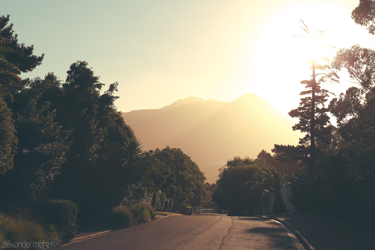 Foto von A tranquil Cape Town street at sunrise, silhouetted against the majestic mountains.