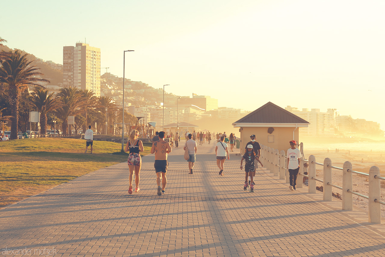 Foto von Joggers and walkers enjoy a golden sunset along Cape Town's breezy promenade.