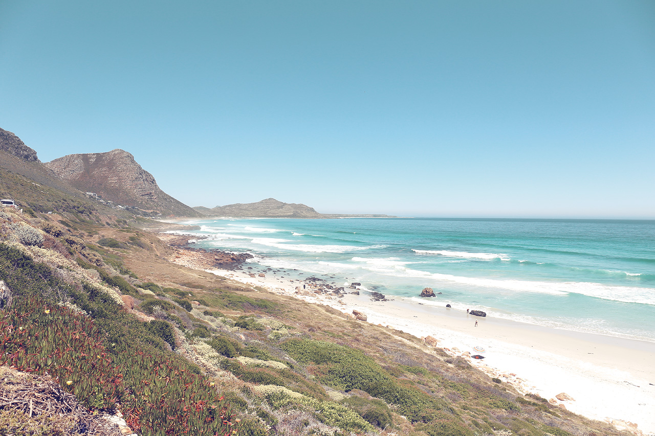 Foto von The pristine shores of Cape Town, South Africa, where rugged cliffs meet endless turquoise waves under a vast sky.