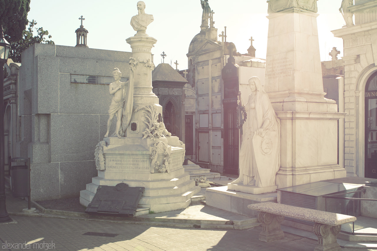 Recoleta's Whisper Foto von Statues and mausoleums bathed in sunlight at Recoleta Cemetery, Buenos Aires, evoke tales from the past amidst tranquil shadows.
