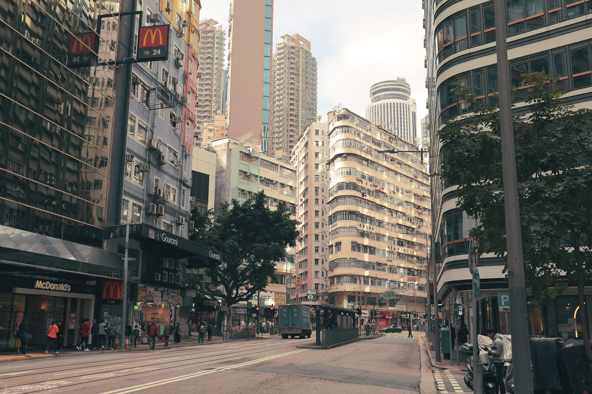 Foto von Tram tracks and city bustle framed by tong lau and glass towers on Hennessy Road, Wan Chai District, Hong Kong.