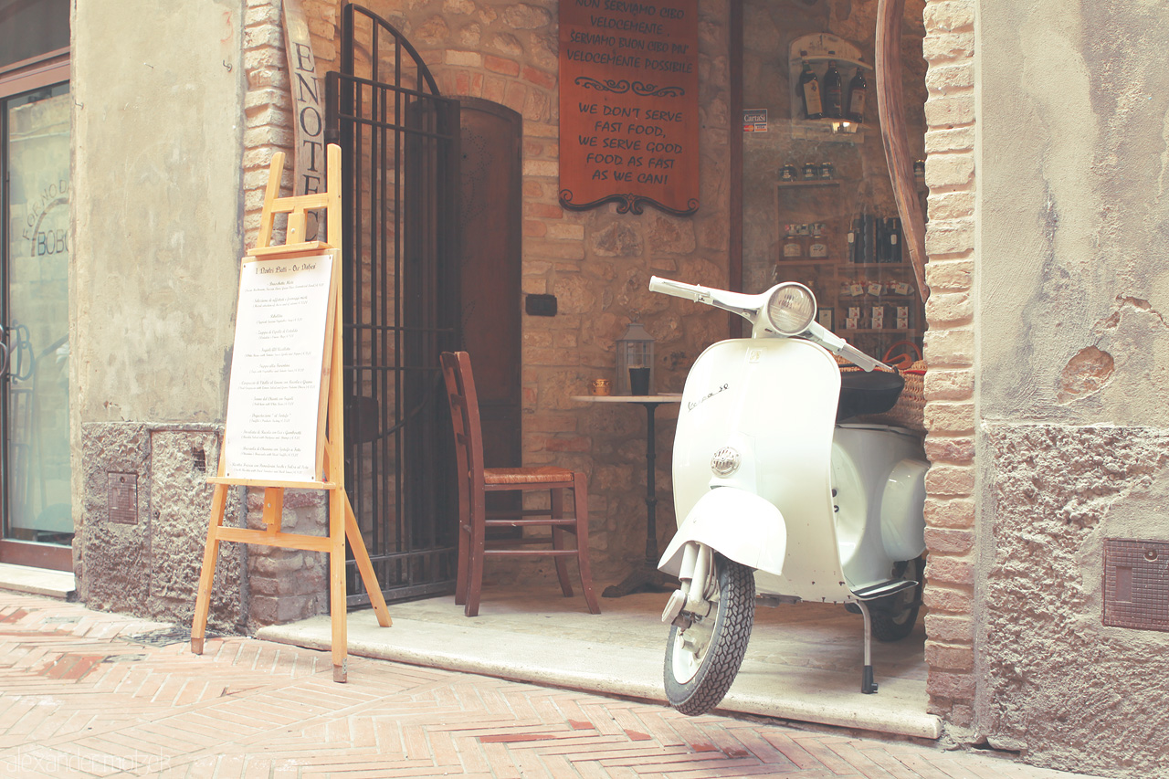 Foto von A charming Vespa rests at a rustic café in the heart of Tuscany, exuding an air of timeless Italian allure.