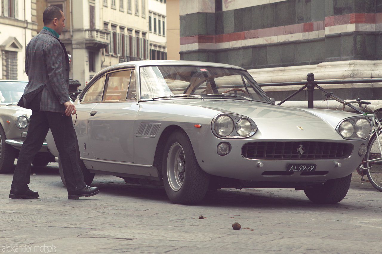 Foto von A vintage Ferrari graces the cobbled streets of Florence, embodying timeless Italian elegance and style.