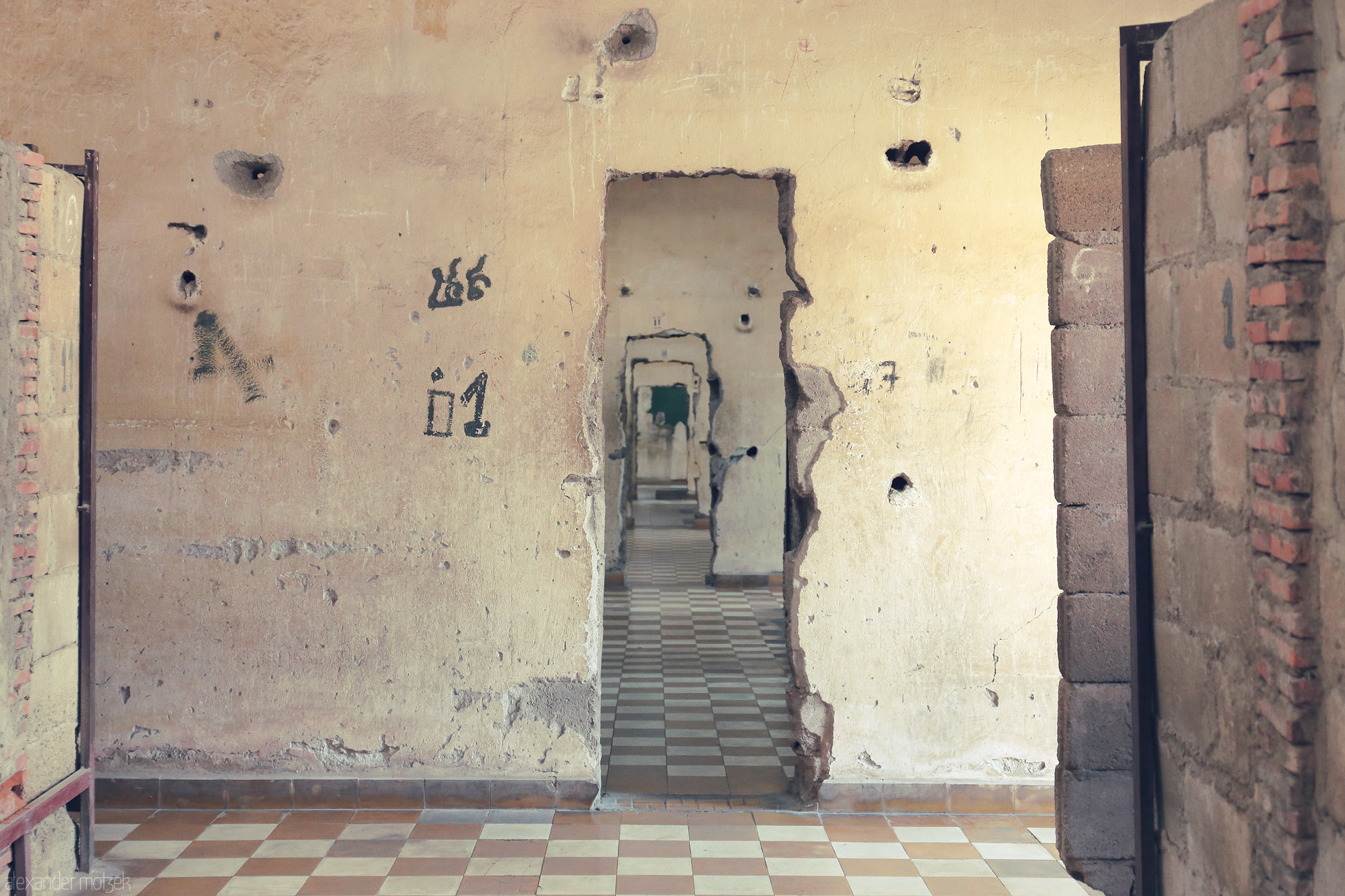 Foto von War-torn walls in Phnom Penh’s Tuol Sleng, doors and scars echo Cambodia’s haunted past, stillness woven into each fading tile and memory.