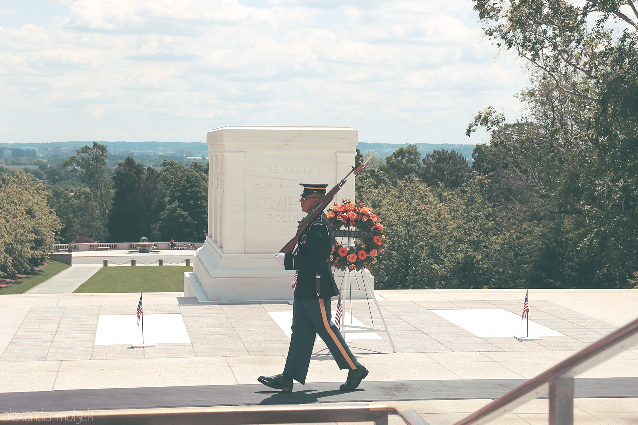 Foto von A solemn soldier marches at the Tomb of the Unknowns in Arlington, Virginia, under the gentle embrace of nature's watchful gaze.